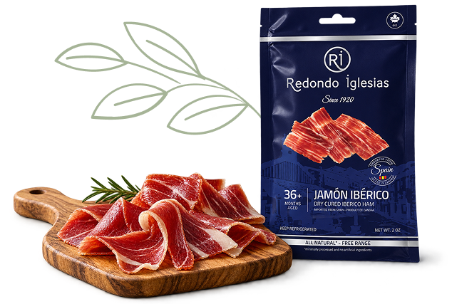 Redondo Iglesias 36-month aged Jamón Ibérico with thinly sliced cured ham served on a wooden board.